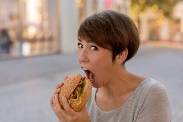 Pretty young woman biting into a hamburger