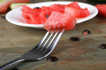 watermelon sliced on a plate on a wooden background
