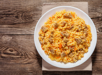 A delicious pilaf in a dish on the old board