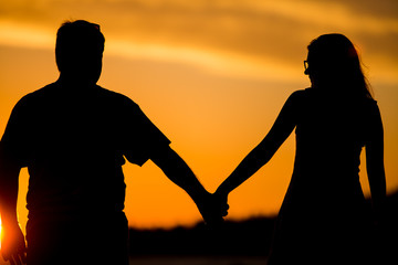 Fototapeta na wymiar Young couple walk on the sunset