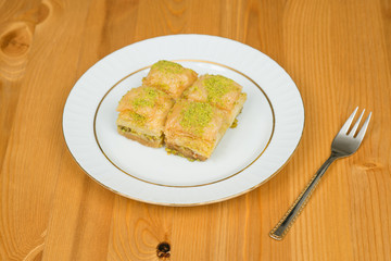 baklava with pistachio. turkish traditional delight on a wood background.