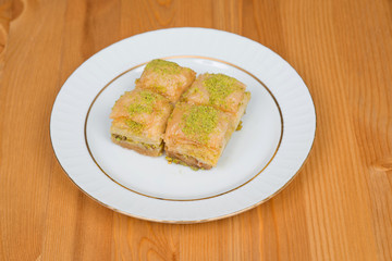 baklava with pistachio. turkish traditional delight on a wood background.