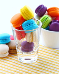 Traditional french colorful macarons in a glass on white.