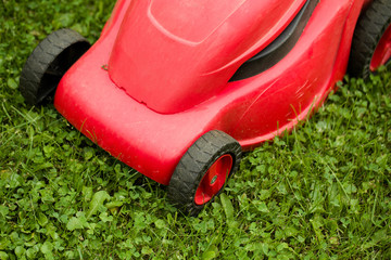 Fototapeta premium red lawnmower on green grass