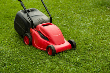 Fototapeta na wymiar red lawnmower on green grass