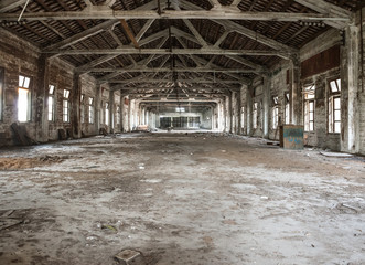 Empty industrial loft in an architectural background with bare cement walls, floors and pillars supporting a mezzanine