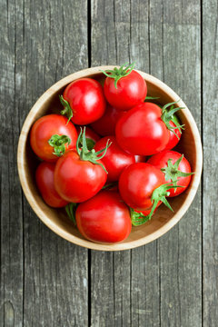 red tomatoes in wooden bowl