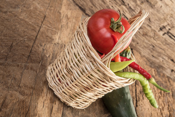fresh vegetables in a basket on wooden table