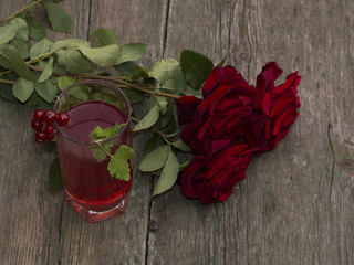 bouquet of beautiful roses and glass of juice of red color