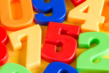 Fototapeta premium Colorful plastic numbers on a wooden table