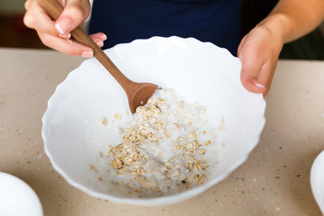 Young woman making a dough from oatmeal