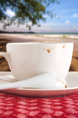 cup of coffee with coffee mark on red fabric a sea background