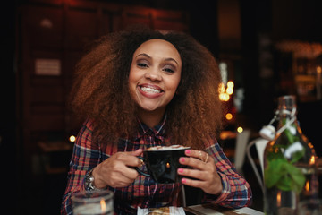 Young woman drinking coffee at cafe