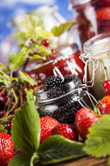 Glass of mixed berry jam with strawberries, bilberries, red currants and blackberries