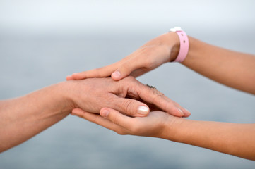 Child holding mother hand with tender