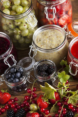 Glass of mixed berry jam with strawberries, bilberries, red currants and blackberries