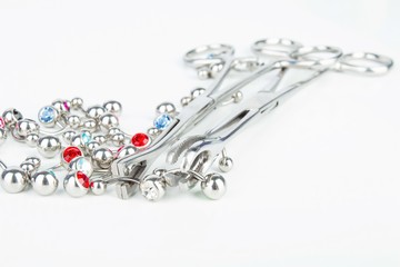 Professional body piercing instruments: forceps and jewelry. 