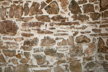 Old wall with many small and big stones