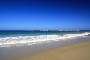 Sea waves with foam on white tropical sandy beach