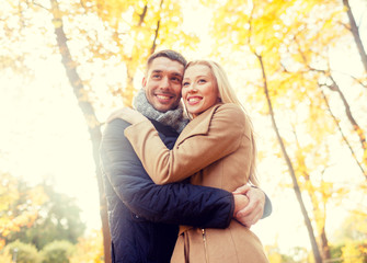 Fototapeta premium smiling couple hugging in autumn park