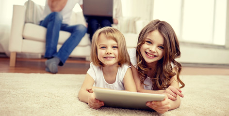 happy little girls with tablet pc computer at home