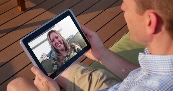 Man Video Chats with Woman on Tablet PC Outside