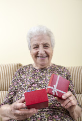 happy senior woman opening gift