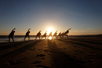 yoga lesson on the beach at sunset