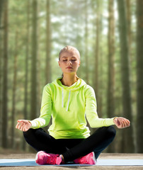 Fototapeta premium happy young woman doing yoga outdoors