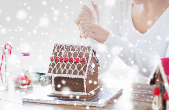close up of woman making gingerbread house at home