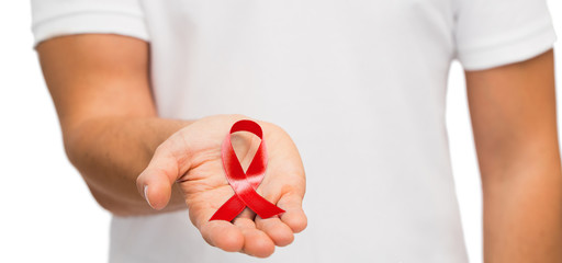 hand with red aids or hiv awareness ribbon - obrazy, fototapety, plakaty