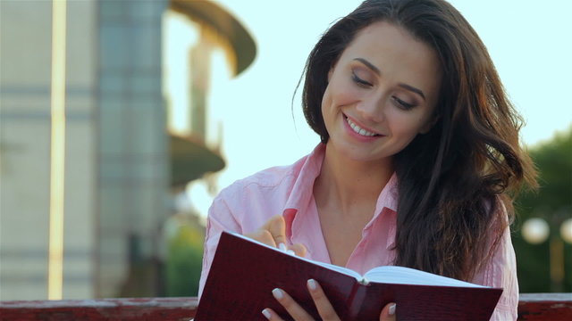 Young beautiful girl making notes 