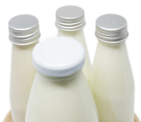 Soy milk bottles on wooden plate isolated
