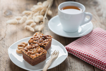 Toffee cake with tea cup on wood table.