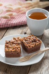 Toffee cake with tea cup on wood table.