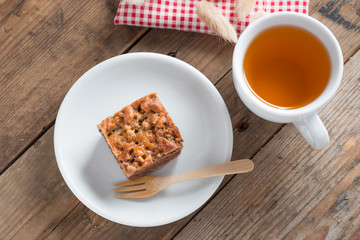 Toffee cake with tea cup on wood table.