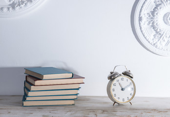 Shelf with books and an alarm clock