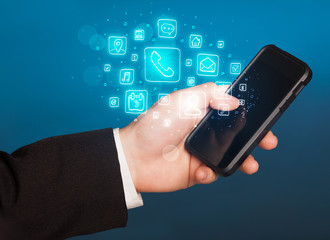 Hand holding smartphone with mobile app icons