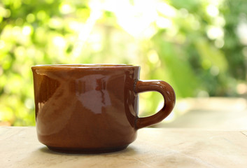 coffee cup on wooden table with blurred background