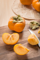 Cutted of Persimmon fruit on wood cutting board.