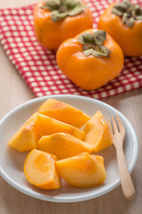 Fresh Persimmon fruit in white dish.