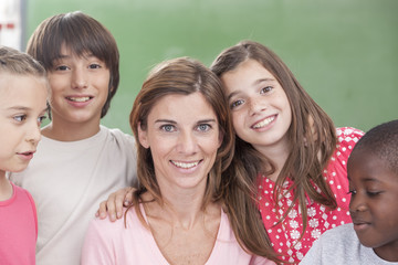 Obraz premium Pupils and teacher looking at camera