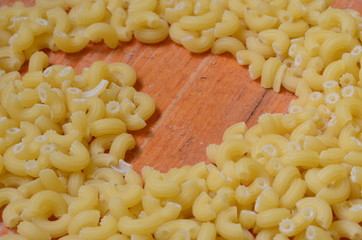 Italian pasta on brown wooden background.