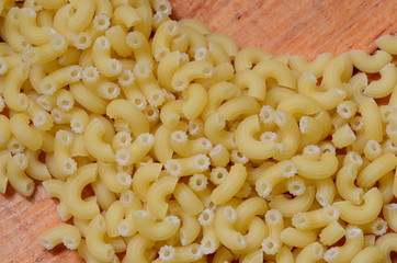 Italian pasta on brown wooden background.