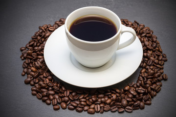 Kaffee Tasse mit Kaffeebohnen auf Schieferplatte