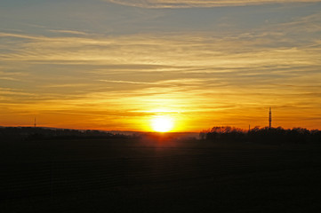 Sonnenuntergang/Sonnenuntergang &uuml;ber einer Landschaft in Deutschland, im Vordergrund Felder, Abendhimmel mit gelben Wolken
