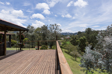 Fototapeta na wymiar Large wood deck near house with spring landscape.
