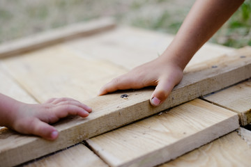Kids holding hands on wooden board in workshop