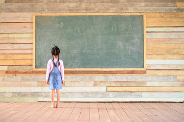 Little girl look at blackboard