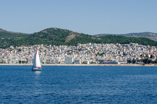 City of Kavala Greece viewed from ferry.Small sailboat